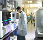 Cobas TaqMan being loaded with samples for analysis; background - clinical samples and reagents being prepared